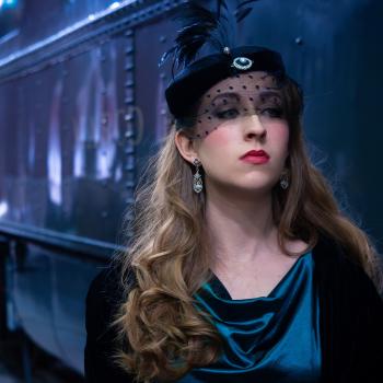 A woman in front of a train in fancy dress