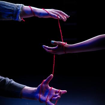 Hands tangled amongst a string